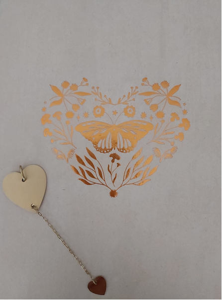 Illustration florale dorée en forme de cœur avec un papillon